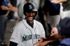 Sunflower seeds fly in the dugout as Seattle Mariners' Kyle Lewis is greeted after he hit a solo home run against the Cincinnati Reds during the fifth inning of a baseball game Thursday, Sept. 12, 2019, in Seattle. (AP Photo/Ted S. Warren)