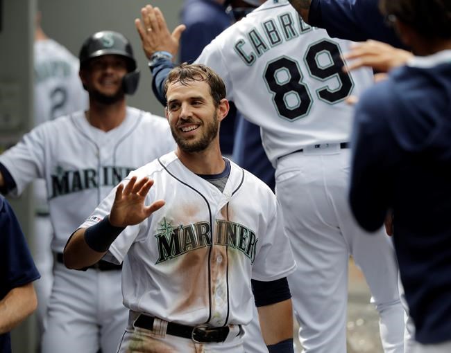Seattle Mariners' Austin Nola, center, and Kristopher Negron, left, are greeted in the dugout after they scored in the seventh inning of a baseball game against the Detroit Tigers on a ground-rule double hit by teammate Ryan Court, Saturday, July 27, 2019, in Seattle. (AP Photo/Ted S. Warren)