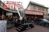 Fans wearing Seattle Sounders gear pose for a photo with a giant replica of the MLS Cup trophy, Friday, Nov. 8, 2019, at Pike Place Market in Seattle. Toronto FC is scheduled to face the Seattle Sounders on Sunday in the MLS Cup soccer match in Seattle, the third time the two teams will have met for the MLS championship. (AP Photo/Ted S. Warren)