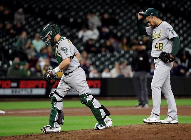 Oakland Athletics pitcher Joakim Soria (48) stands on the mound after a conference with catcher Nick Hundley, left, during the 10th inning of a baseball game, Monday, May 13, 2019, in Seattle. Soria gave up a walk-off, RBI-single to Seattle Mariners' Omar Narvaez later in the inning and was charged with the loss after the Mariners won 6-5 in 10 innings. (AP Photo/Ted S. Warren)
