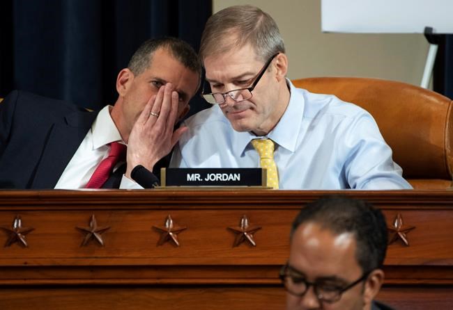 Steve Castor, Republican staff attorney for the House Oversight Committee, left, speaks to Rep. Jim Jordan, R-Ohio, during the House Intelligence Committee on Capitol Hill in Washington, Wednesday, Nov. 13, 2019, in the first public impeachment hearing of President Donald Trump's efforts to tie U.S. aid for Ukraine to investigations of his political opponents. (Saul Loeb/Pool Photo via AP)