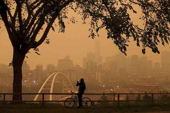 CPA morning commuter stops to take a photo of the city as smoke from the B.C. wildfires rolls in over Edmonton on Wednesday August 15, 2018.THE CANADIAN PRESS/Jason Franson