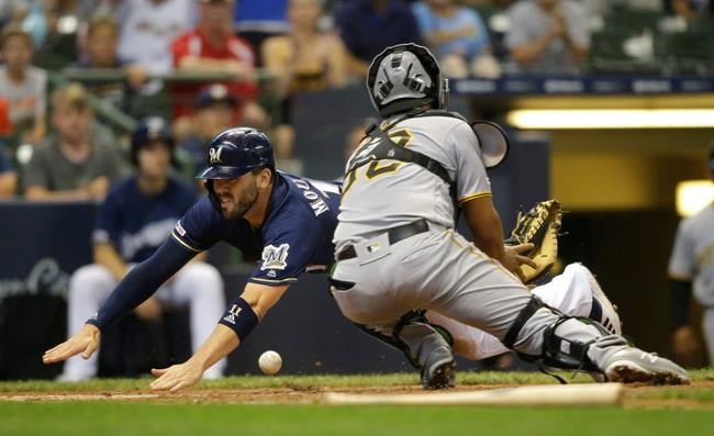 Milwaukee Brewers' Mike Moustakas scores as Pittsburgh Pirates catcher Elias Diaz can't handle the throw during the fourth inning of a baseball game Sunday, June 30, 2019, in Milwaukee. (AP Photo/Jeffrey Phelps)