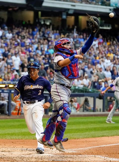 Milwaukee Brewers' Trent Grisham scores past Texas Rangers catcher Jose Trevino during the fourth inning of a baseball game Saturday, Aug. 10, 2019, in Milwaukee. Grisham scored from second on a hit by Mike Moustakas. (AP Photo/Morry Gash)