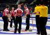 CP
Two of China's players look on as Jeff Stoughton's rink celebrates after defeating China 5-4  on Thursday.