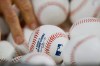 A Washington Nationals player reaches for a ball during batting practice before Game 2 of the baseball World Series against the Houston Astros Wednesday, Oct. 23, 2019, in Houston. (AP Photo/Matt Slocum)