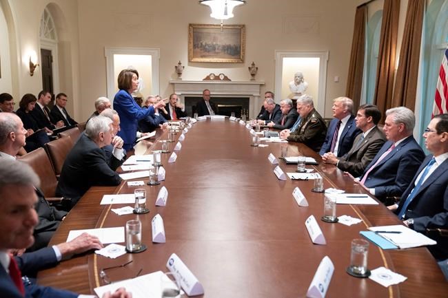 In this photo released by the White House, President Donald Trump, center right, meets with House Speaker Nancy Pelosi, standing left, Congressional leadership and others, Wednesday, Oct. 16, 2019, in the Cabinet Room of the White House in Washington. (Official White House Photo by Shealah Craighead via AP)