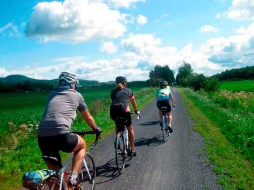 Cyclists on Velo Quebec's Grand Tour sweep along a trail in the Eastern Townships, Aug. 1, 2015. More than 1,200 cyclists took part in the ride, which dipped into Vermont. This year's Grand Tour is in the Saguenay-Lac Saint-Jean region. Velo Quebec is steward of Route Verte, a vast network of bicycle routes that has made Quebec a leading destination for cyclists. (AP Photo/Cal Woodward)