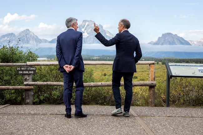 Federal Reserve Chairman Jerome Powell, left, and Bank of England Governor Mark Carney, right, pause in front of Mt. Moran after Powell's speech at the Jackson Hole Economic Policy Symposium on Friday, Aug. 23, 2019, in Jackson Hole, Wyo. (AP Photo/Amber Baesler)