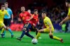 Spain's Santi Carzola, center, send the ball past Romania's Razvan Rus during the Euro 2020 group F qualifying soccer match between Spain and Romania at the Metropolitano stadium in Madrid, Monday, Nov. 18, 2019. (AP Photo/Manu Fernandez)