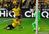 Dortmund's Christian Pulisic, on the ground, scores the opening goal past Duesseldorf goalkeeper Michael Rensing, right, during the German Bundesliga soccer match between Borussia Dortmund and Fortuna Duesseldorf in Dortmund, Germany, Saturday, May 11, 2019. (AP Photo/Martin Meissner)