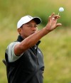 Tiger Woods of the United States catches a golf ball as he prepares to hit practice shots ahead of the start of the British Open golf championships at Royal Portrush in Northern Ireland, Tuesday, July 16, 2019. The British Open starts Thursday. (AP Photo/Jon Super)