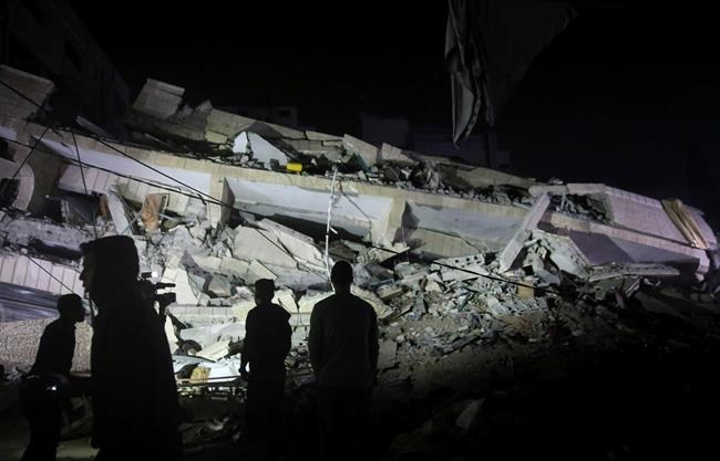 Residents inspect the damage of the destroyed multi-story building in Gaza City, Saturday, May 4, 2019. Palestinian militants on Saturday fired over 200 rockets into Israel, drawing dozens of retaliatory airstrikes on targets across the Gaza Strip in a round of intense fighting that broke a monthlong lull between the bitter enemies. Three Palestinians, including a mother and her baby daughter, were killed, while three Israelis, including an 80-year-old woman, were wounded by rocket fire. (AP Photo/Adel Hana)