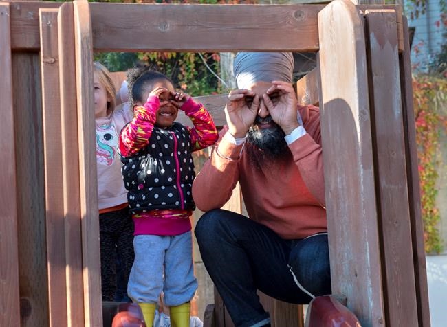 NDP Leader Jagmeet Singh and a young girl imitate the cameras as they stand on a play structure during a campaign stop at Hastings Park Childcare in Vancouver on Monday, Sept. 30, 2019. THE CANADIAN PRESS/Andrew Vaughan