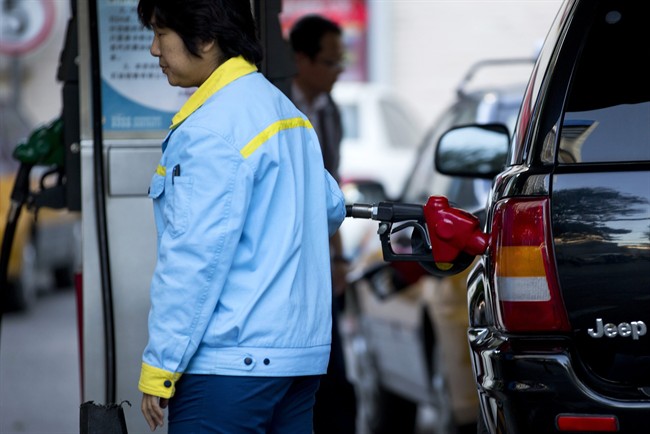 A petrol attendant fills a car at a China National Petroleum Corporation (CNPC) petrol station in Beijing, China Thursday, Oct. 10, 2013. China passed the United States in September as the world's biggest net oil importer, driven by faster economic growth and strong auto sales, according to U.S. government data released this week. (AP Photo/Andy Wong)