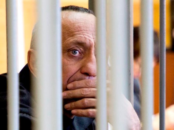 Mikhail Popkov looks through bars during a court session in Irkutsk, Russia, Monday, Dec. 10, 2018. A court in Russia's eastern Siberia on Monday convicted Popkov, a former policeman of murdering 56 women, bringing the number he is believed to have killed to at least 78. (Julia Pykhalova, Komsomolskaya Pravda via AP)