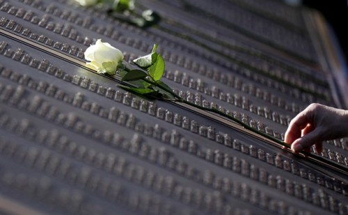 An unidentified woman places a rose on the Titanic Memorial Plaque during the service at Belfast City Hall, Northern Ireland, Sunday, April 15, 2012 one-hundred years after the Titanic sank. The Titanic passenger liner was built in Belfast, and sank in the North Atlantic Ocean on its maiden voyage from England to New York, USA, in the early hours of April 15, 1912, after colliding with an iceberg and over 1,500 people perished in the sinking. (AP Photo/Peter Morrison)