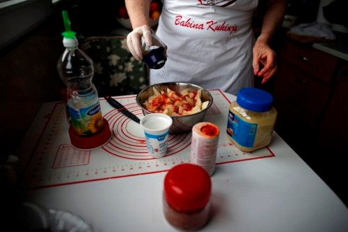 Jelena Petrovic prepares the food in her home in Jagodina, Serbia, Tuesday, Feb. 12, 2019. Serbs looking for ideas are increasingly turning to the Balkan country's hit chef Granny Jela, an elderly lady who has put her life-long experience to good use and launched an online cooking tutorial. Jelena Petrovic's YouTube channel and blog dubbed Granny's Kitchen have had over 50 million of views and nearly 150,000 subscribers who check in daily for a new recipe of home-made food. (AP Photo/Darko Vojinovic)