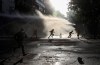 Anti-government protesters runs amid the spray of a police water cannon in Santiago, Chile, Wednesday, Oct. 30, 2019. Chilean President Sebastián Pinera cancelled two major international summits after nearly two weeks of nationwide protests over economic inequality that have left at least 20 dead and damaged businesses and infrastructure around the country. (AP Photo/Esteban Felix)