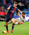 PSG's Thomas Meunier, left, and Bordeaux's Nicolas De Preville challenge for the ball during the French League One soccer match between Paris Saint-Germain and Bordeaux at the Parc des Princes stadium in Paris, Saturday, Feb. 9, 2019. (AP Photo/Christophe Ena)
