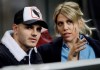 FILE - In this Thursday, Feb. 21, 2019, Inter Milan's Mauro Icardi is flanked by his wife Wanda Nara as they sit in the stands during the Europa League, round of 32, second leg soccer match between Inter Milan and SK Rapid Vienna, at the San Siro stadium in Milan, Italy. Mauro Icardi has been left off Inter Milan‚Äôs squad for Sunday‚Äôs match against Lazio following a six-week exile from the club. Icardi resumed training with Inter over the international break, having seemingly cleared up his differences with the club after being stripped of the captaincy amid protracted contract negotiations. So it was a surprise when Inter coach Luciano Spalletti announced Saturday that he now sees Icardi ‚Äúlike a new player as he was out for so long. I still hold that he can‚Äôt be ready yet to help his teammates so he won‚Äôt be in the squad tomorrow.‚Äù (AP Photo/Luca Bruno, File)