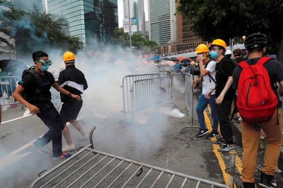 Kin Cheung / The Associated PressProtestors react to tear gas during a large protest near the Legislative Council in Hong Kong, Wednesday, June 12, 2019. Hong Kong police have used tear gas and high-pressure hoses against thousands of protesters opposing a highly controversial extradition bill outside government headquarters. (AP Photo/Kin Cheung)