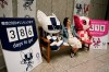 A woman pauses for photos with Tokyo 2020 mascots and displays showing the number of days to go until the opening ceremony of next year's Olympics Thursday, July 4, 2019, in Tokyo. Overwhelmed by unprecedented demand, Tokyo Olympic organizers said Thursday they would run another ticket lottery next month for residents of Japan to view the games. (AP Photo/Jae C. Hong)