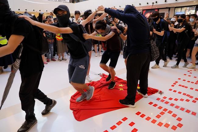 Protesters walk on a Chinese national flag during a protest at a mall in Hong Kong on Sunday, Sept. 22, 2019. Hong Kong's pro-democracy protests, now in their fourth month, have often descended into violence late in the day and at night. A hardcore group of protesters says the extreme actions are needed to get the government's attention. (AP Photo/Kin Cheung)