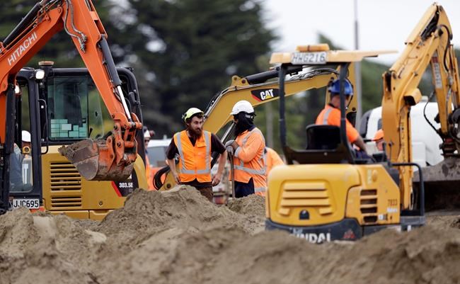 Workers watch as graves are prepared at a Muslim cemetery following the Friday mass shootings at two mosques in Christchurch, New Zealand, Sunday March 17, 2019. The live-streamed attack by an immigrant-hating white nationalist killed dozens of people as they gathered for weekly prayers in Christchurch on Friday March 15. (AP Photo/Mark Baker)