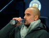 Manchester City coach Pep Guardiola drinks a water as he waits for the start of the Champions League round of 16 second leg, soccer match between Manchester City and Schalke 04 at Etihad stadium in Manchester, England, Tuesday, March 12, 2019. (AP Photo/Dave Thompson)