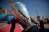 Workers install a giant replica of the Champions League trophy ahead of the UEFA group stage draw outside the Grimaldi Forum, in Monaco, Thursday, Aug. 29, 2019. (AP Photo/Daniel Cole)