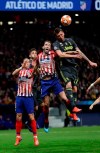 Juventus forward Mario Mandzukic, right, heads the ball as Atletico defender Diego Godin, center, defends during the Champions League round of 16 first leg soccer match between Atletico Madrid and Juventus at Wanda Metropolitano stadium in Madrid, Wednesday, Feb. 20, 2019. (AP Photo/Manu Fernandez)