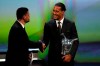 Dutch soccer player Virgil van Dijk of Liverpool, right, holds the award of men's player of the year 2018/19 during the UEFA Champions League group stage draw at the Grimaldi Forum, in Monaco, Thursday, Aug. 29, 2019. (AP Photo/Daniel Cole)