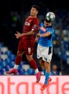 Liverpool's Roberto Firmino, left, and Napoli's Kostas Manolas jump for the ball during the Champions League Group E soccer match between Napoli and Liverpool, at the San Paolo stadium in Naples, Italy, Tuesday, Sept. 17, 2019. (AP Photo/Gregorio Borgia)