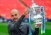 Manchester City's manager Pep Guardiola poses with the trophy after the English FA Cup Final soccer match between Manchester City and Watford at Wembley stadium in London, Saturday, May 18, 2019. (AP Photo/Kirsty Wigglesworth)