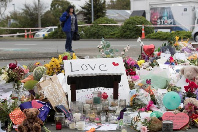 Flowers are placed to pray for the victims of Friday's attack outside the Linwood mosque in Christchurch, New Zealand, Tuesday, March 19, 2019. Christchurch was beginning to return to a semblance of normalcy Tuesday. Streets near the hospital that had been closed for four days reopened to traffic as relatives and friends of the victims continued to stream in from around the world. (AP Photo/Vincent Thian)