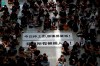 Protesters surround banners that read: 