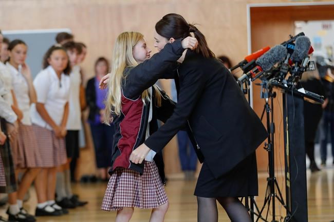 New Zealand's Prime Minister Jacinda Ardern, right, hugs and consoles a student during a high school visit in Christchurch, New Zealand, Wednesday, March 20, 2019. (AP Photo/Vincent Thian)