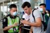 An airport security officer checks on a traveller's flight information at the airport main entrance gate in Hong Kong, Wednesday, Aug. 14, 2019. Flights resumed at Hong Kong's airport Wednesday morning after two days of disruptions marked by outbursts of violence that highlight the hardening positions of pro-democracy protesters and the authorities in the semi-autonomous Chinese city. (AP Photo/Vincent Thian)