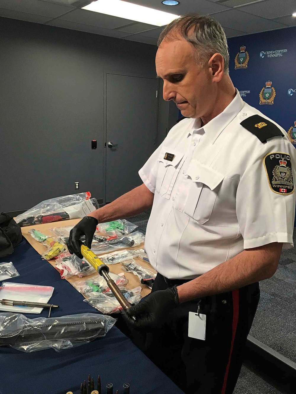 KEVIN ROLLASON / WINNIPEG FREE PRESS
Max Waddell of the organized crime unit inspects one of the seized homemade firearms