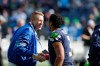 In this Oct. 13, 2013, file photo, Seattle hip hop and rap singer Macklemore, left, greets Seattle Seahawks quarterback Russell Wilson before an NFL football game between the Seahawks and Tennessee Titans in Seattle. The MLS soccer Seattle Sounders team announced Tuesday, Aug. 13, 2019, that they are adding Macklemore and Wilson to club's ownership group, along with several others as Hollywood producer Joe Roth leaves the franchise.(AP Photo/Elaine Thompson, File)