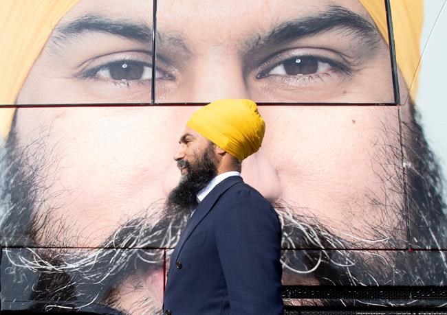 NDP leader Jagmeet Singh walks past the campaign bus during a campaign stop in Longueuil, Que. Monday September 16, 2019. THE CANADIAN PRESS/Adrian Wyld