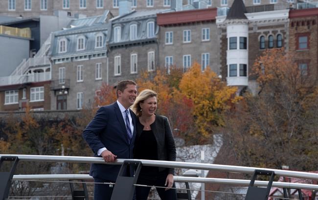 Conservative Leader Andrew Scheer and his wife Jill Scheer walk across a bridge following a campaign stop in Quebec City, Tuesday October 15, 2019. THE CANADIAN PRESS/Adrian Wyld