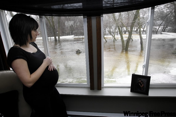 JOE BRYKSA / WINNIPEG FREE PRESS
A pregnant Amanda Chopp watches water rise in the rear of her home near Lorette.
