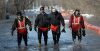 Phil Hossack / Winnipeg Free Press
A city crew wades out of Christie road where a “Tiger” tube dike was overwhelmed in a low sec­tion of the road. Homes were not affected, and flooding was localized.