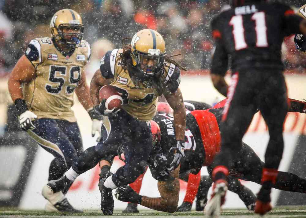 CP
Winnipeg Blue Bombers Paris Cotton, centre, dodges Calgary Stampeders players during first half CFL football action in Calgary, Saturday, Nov. 1, 2014.