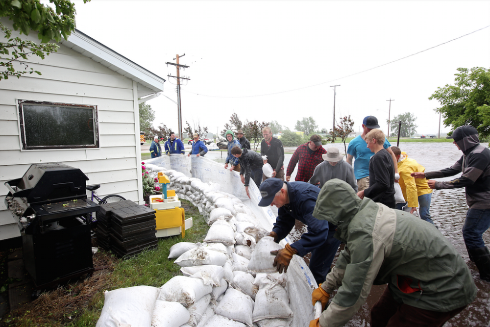 Members of the community join together in Brandon to sandbag.