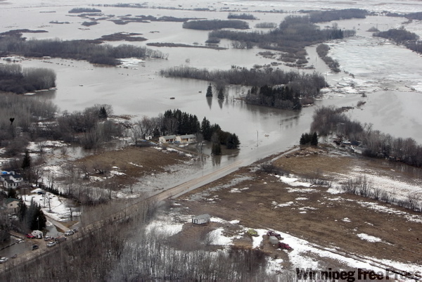 Breezy Point Road is left submerged Sunday after several shifts in the ice jam north of Selkirk forced river water to inundate dozens of homes in the RMs of St. Andrews and St. Clements.