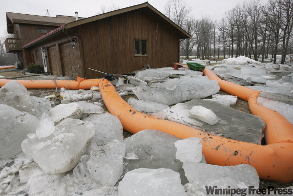 John Woods / The Canadian Press
A home surrounded by ice sits empty on the bank of the Red River in St. Clements. Massive blocks of ice proved to be too much for temporary tube dikes as it was forced onto the shore at Breezy Point and St Clements, early Sunday morning.