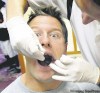 JOE.BRYKSA@FREEPRESS.MB.CA 
Bomber warhorse Doug Brown opens wide for Dr. Scott Leckie, who scrutinizes the defensive lineman's chompers and gives him a passing grade on medical day.